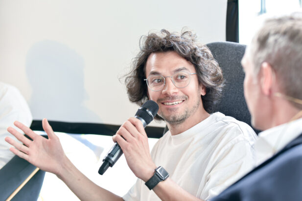 Allan Berger speaking into a microphone during a panel talk.